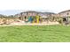 Community playground with a colorful slide, climbing structures, and green space for recreational activities at 10777 Briset Ct, Las Vegas, NV 89166