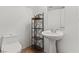 Cozy powder room with a pedestal sink, dark metal shelving and decor, and a tiled floor at 11132 Ferragamo Ct, Las Vegas, NV 89141