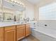 Serene bathroom with soaking tub, wood vanity, and ample counter space at 11132 Ferragamo Ct, Las Vegas, NV 89141