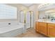 Bright bathroom featuring a glass-enclosed shower, a separate soaking tub, and modern fixtures at 11132 Ferragamo Ct, Las Vegas, NV 89141