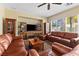 Cozy living room features comfortable leather sofas and a large window that floods the room with natural light at 11132 Ferragamo Ct, Las Vegas, NV 89141