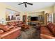 Cozy living room with plush brown leather seating and entertainment center at 11132 Ferragamo Ct, Las Vegas, NV 89141