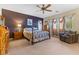 Spacious main bedroom featuring a ceiling fan, plush carpet, and an abundance of natural light at 11132 Ferragamo Ct, Las Vegas, NV 89141