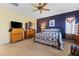Comfortable primary bedroom featuring carpet, a ceiling fan, curtains, and wooden furniture at 11132 Ferragamo Ct, Las Vegas, NV 89141