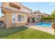 Inviting backyard with a pristine pool, artificial turf, and lush landscaping at 12048 Portamento Ct, Las Vegas, NV 89138