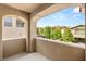 Charming balcony framed by arches, offering a view of lush greenery and neighborhood rooftops at 12048 Portamento Ct, Las Vegas, NV 89138