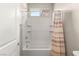 Cozy bathroom with a shower-tub combination, featuring a shower curtain and a bright window at 12048 Portamento Ct, Las Vegas, NV 89138