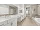 Spacious bathroom with tile flooring, featuring dual sinks, a separate shower, and a tub, designed for modern living at 12048 Portamento Ct, Las Vegas, NV 89138