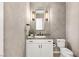 Stylish half bathroom with modern fixtures and a decorative mirror and sconces at 12048 Portamento Ct, Las Vegas, NV 89138