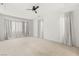 Spacious bedroom with a ceiling fan, featuring plush carpet flooring and sheer curtains, offering a relaxing space at 12048 Portamento Ct, Las Vegas, NV 89138