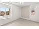 Bright bedroom with large windows, neutral carpeting, and a unique accent wall at 12048 Portamento Ct, Las Vegas, NV 89138