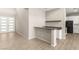 Open concept kitchen adjacent to the living room featuring granite countertop, stainless steel appliances, and black cabinetry at 12048 Portamento Ct, Las Vegas, NV 89138