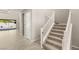Hallway with a staircase featuring carpeted steps and a white railing, leading to the upper floors of the house at 12048 Portamento Ct, Las Vegas, NV 89138