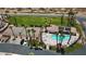 A captivating aerial view showcasing a community pool, a tennis court, mature palm trees and meticulous landscaping at 1223 Golf Club Dr, Laughlin, NV 89029
