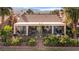 Charming backyard with a covered patio, lush greenery, and colorful flowers creating a serene outdoor living space at 1223 Golf Club Dr, Laughlin, NV 89029