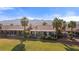 Expansive backyard featuring a covered patio, well-manicured lawn, and mature trees, offering ample space for recreation at 1223 Golf Club Dr, Laughlin, NV 89029