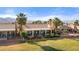 Spacious backyard showcasing a covered patio, lush lawn, and mature palms, providing a resort-like atmosphere at 1223 Golf Club Dr, Laughlin, NV 89029