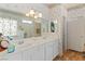 Bright bathroom featuring a double sink vanity and a separate tub with decorative screens at 1223 Golf Club Dr, Laughlin, NV 89029