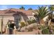 Inviting single-story home featuring a well-manicured front yard, charming desert landscaping, and covered entry way at 1223 Golf Club Dr, Laughlin, NV 89029