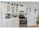 Modern kitchen with stainless steel appliances, white cabinets, and tile countertops, ideal for cooking and entertaining at 1223 Golf Club Dr, Laughlin, NV 89029