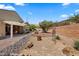 Beautifully landscaped backyard featuring a covered patio area and desert landscape at 1561 Campfire Ln, Mesquite, NV 89034