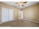 Bright, carpeted bedroom featuring double closets, neutral paint, and a ceiling fan at 1561 Campfire Ln, Mesquite, NV 89034
