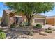 Charming single-story home featuring stone accents, desert landscaping, and a well-maintained front yard with mature shade tree at 1561 Campfire Ln, Mesquite, NV 89034