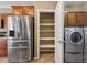 Kitchen featuring stainless steel appliances and a pantry, with laundry machines in the adjacent space at 1561 Campfire Ln, Mesquite, NV 89034