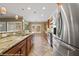 Well-lit kitchen featuring stainless steel refrigerator, granite countertops, and wooden cabinets at 1561 Campfire Ln, Mesquite, NV 89034