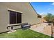 This side yard features artificial turf, a window, and a paved path with outdoor lighting at 1561 Campfire Ln, Mesquite, NV 89034