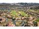 Stunning aerial view of a community with a golf course, lake, and homes with red tile roofs and mountain views at 16 Cerchio Basso, Henderson, NV 89011