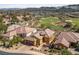 Stunning aerial view of a yellow home on a golf course with mountain views at 16 Cerchio Basso, Henderson, NV 89011