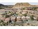 Aerial view showcases hillside community with tile-roofed homes, landscaped yards, and mountain backdrop at 16 Cerchio Basso, Henderson, NV 89011