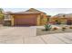 Single-story home with attached garage, desert landscaping, and a paved driveway at 16 Cerchio Basso, Henderson, NV 89011