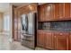 Kitchen features stainless steel refrigerator and plenty of dark wood cabinet space at 16 Cerchio Basso, Henderson, NV 89011