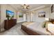 Staged bedroom features neutral walls, wood furniture, and art at 16 Cerchio Basso, Henderson, NV 89011