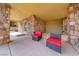 Covered patio with stone columns, seating, and views of the surrounding landscape at 16 Cerchio Basso, Henderson, NV 89011