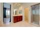Bright bathroom with tile flooring, double sink vanity with mirror, glass enclosed shower and plantation shutters at 17 Stonemark Dr, Henderson, NV 89052