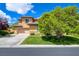 Inviting stucco two-story home with a well-manicured lawn, mature trees, and a spacious driveway and 2-car garage at 17 Stonemark Dr, Henderson, NV 89052