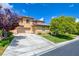 Inviting stucco two-story home with a well-manicured lawn, mature trees, and a spacious driveway and 2-car garage at 17 Stonemark Dr, Henderson, NV 89052