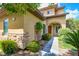 Charming home exterior featuring stone accents, a well-maintained landscape, and an inviting archway leading to the front door at 17 Stonemark Dr, Henderson, NV 89052