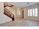 Bright living room with light hardwood floors, large windows, and a view of the staircase to the second floor at 17 Stonemark Dr, Henderson, NV 89052