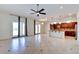 Bright open-concept living area with tile floors, ceiling fan and gourmet kitchen view with granite countertops at 17 Stonemark Dr, Henderson, NV 89052