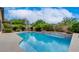 Backyard featuring a sparkling blue swimming pool surrounded by lush landscaping at 17 Stonemark Dr, Henderson, NV 89052
