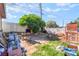 Exterior of a cluttered backyard with a grill, tree, and privacy fence at 1708 Weeping Willow Ln, Las Vegas, NV 89104