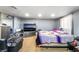 Spacious bedroom featuring neutral walls, light wood flooring, and a large television at 1708 Weeping Willow Ln, Las Vegas, NV 89104