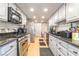 Galley kitchen featuring stainless steel appliances, white cabinets, and granite countertops at 1708 Weeping Willow Ln, Las Vegas, NV 89104