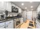 Galley kitchen featuring stainless steel appliances, white cabinets, and granite countertops at 1708 Weeping Willow Ln, Las Vegas, NV 89104