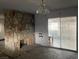 Living room featuring a rustic stone fireplace and sliding glass doors to a patio at 204 Bradshaw Way, Las Vegas, NV 89145
