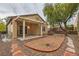 This backyard features a covered patio, fire pit, desert landscaping and a beautiful shade tree at 2152 Mountain City St, Henderson, NV 89052